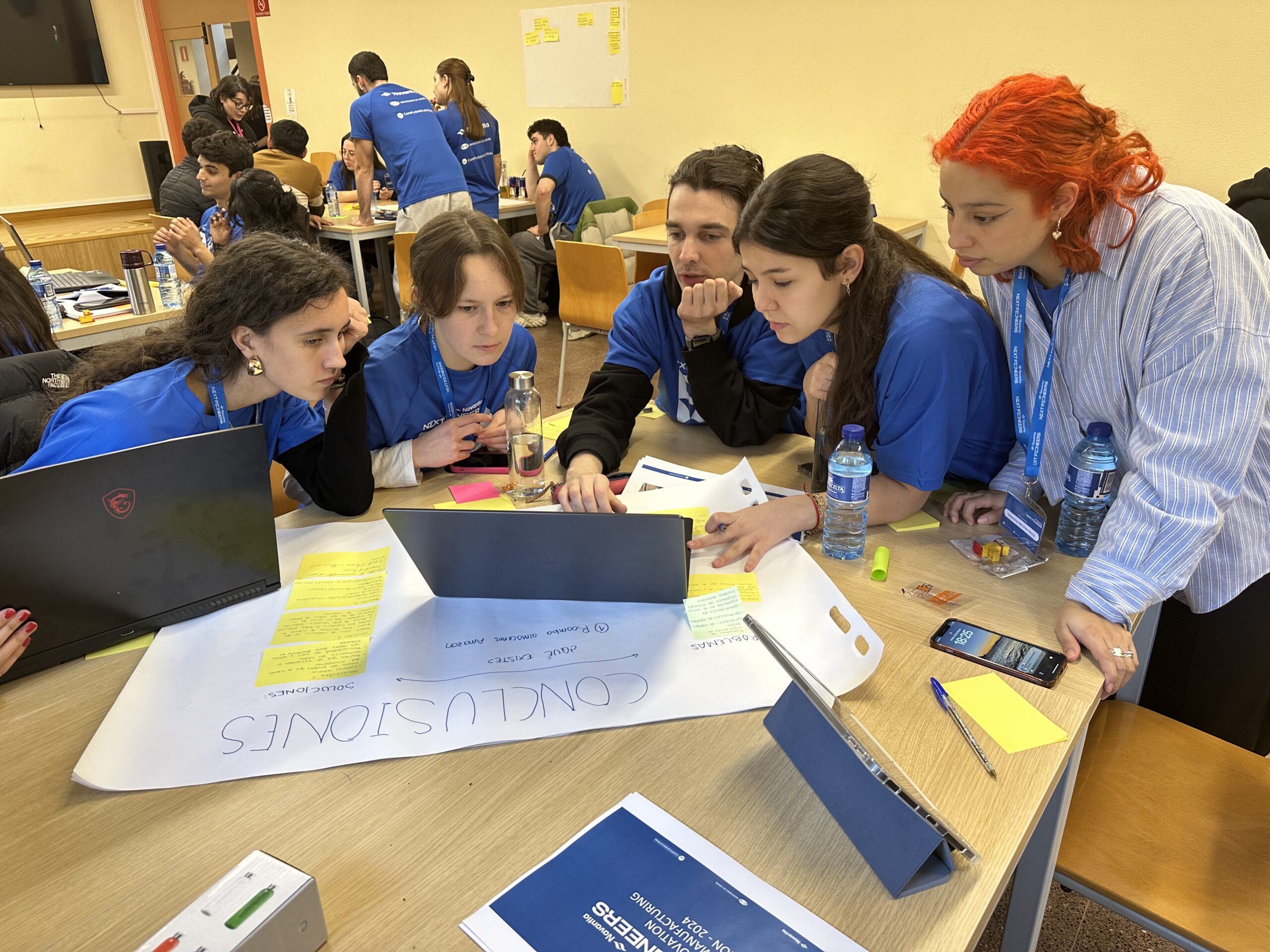 un grupo de estudantes da Escola Universitaria de Deseño Industrial e Desenvolvemento do Produto (EUDI) e da Escola Politécnica de Enxeñaría de Ferrol (EPEF) da Universidade da Coruña (UDC) intentando resolver o reto proposto no Hackathon Navantia Next Pioneers 2024.